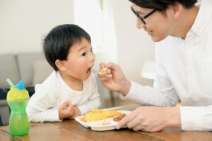 お父さんに食べさせてもらう男の子