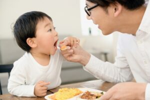 お父さんに食べさせてもらう男の子