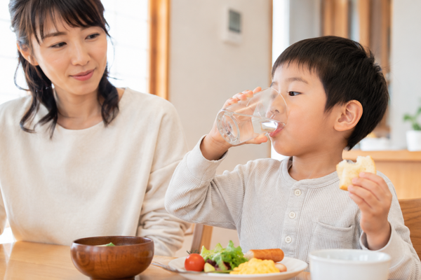 食べながら水を飲む男の子